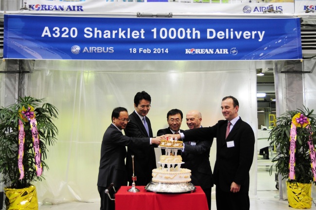 Korean Air executive vice president Cho Won-tae (second from left), Airbus executive vice president for programs Tom Williams (second from right) and other company executives attend a cake-cutting event celebrating the air carrier’s 1,000th delivery of the Airbus-designed “sharklet,” a specialized winglet on the A320, at the Korean firm’s Busan tech center Tuesday. (Korean Air)