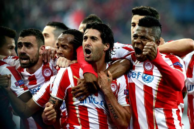 Olympiakos midfielder Alejandro Dominguez (center) celebrates his goal with teammates on Tuesday. (AFP-Yonhap)