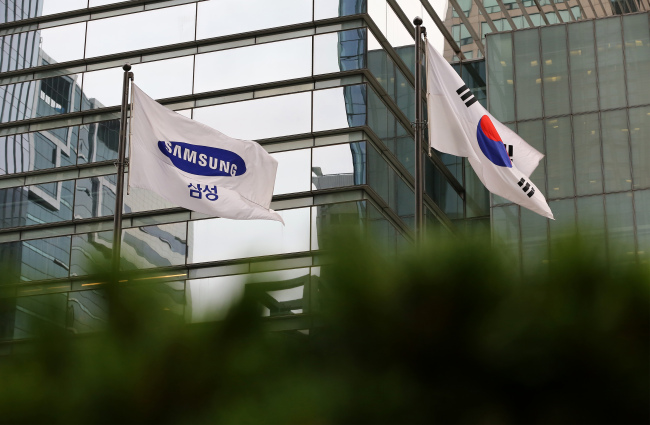 A Samsung Electronics Co. corporate flag, left, and the South Korean national flag fly outside the company's Seocho office building in Seoul. (Bloomberg)