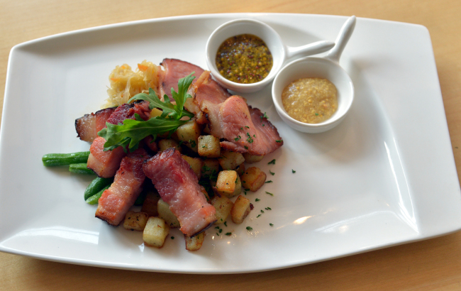 Edelweiss’ smoked meat platter features decadent hunks of salt-cured and smoked bacon and pork with sauerkraut, potatoes, Champagne vinaigrette and beer-bolstered mustards (Yoon Byung-chan/The Korea Herald)