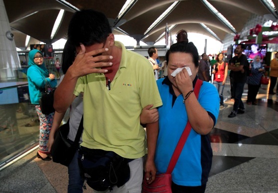 A woman wipes her tears after walking out of the reception center and holding area for family and friend of passengers aboard a missing Malaysia Airlines plane, at Kuala Lumpur International Airport on Saturday. (AP-Yonhap)