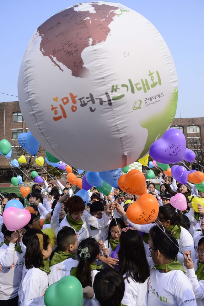 Some 150 elementary school students release balloons carrying letters with messages of hope for children suffering from poverty around the world on Tuesday in Seoul. The event was held by Good Neighbors, an international nonprofit organization based in Seoul. (Park Hae-mook/The Korea Herald)
