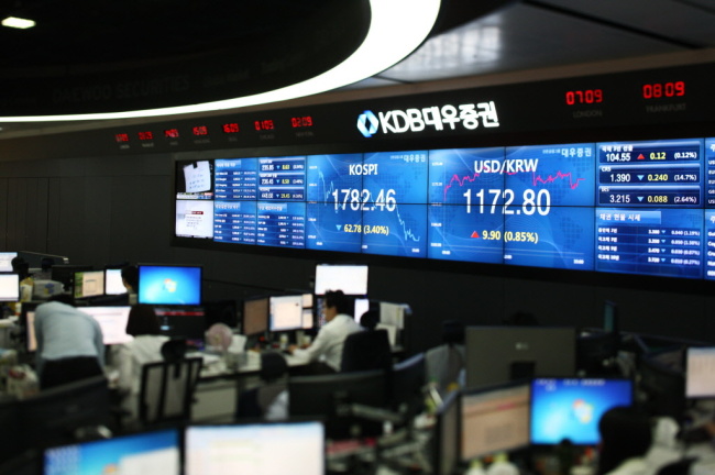 KDB Daewoo Securities employees work in front of a monitor displaying the Korea Composite Stock Price Index (left) and the Korean won to USD exchange rate in the trading room of the company’s headquarters in Yeouido, Seoul. (Bloomberg)