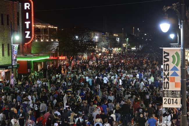 A crowd of people walk along Sixth Street on the last day of South by Southwest in Austin, Texas, Saturday. (EPA-Yonhap)