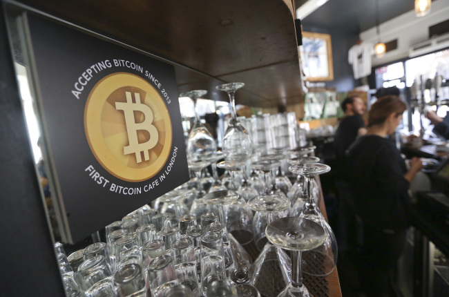 A poster alerting customers that the digital currency Bitcoin is accepted as payment sits behind the counter inside the Old Shoreditch Station cafe in London. (Bloomberg)