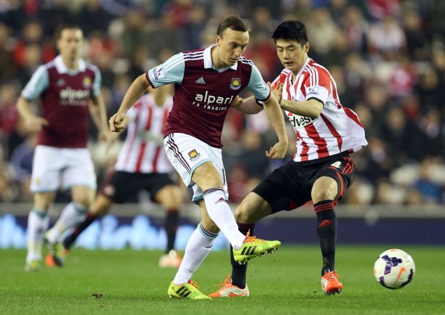 Sunderland’s Ki Sung-yueng (right) and West Ham United’s Mark Noble vie for the ball on Monday. (AFP-Yonhap)