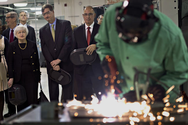 Janet Yellen (left), chair of the U.S. Federal Reserve, and Charles Plosser (second from left), chairman of the Federal Reserve Bank of Chicago, look on as a student uses a cutting torch in the manufacturing lab at Daley College in Chicago, Illinois, Monday. (Bloomberg)