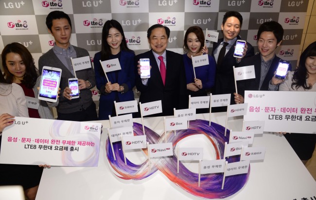 LG Uplus CEO Lee Sang-chul (fourth from left) poses with models after a press conference to launch new LTE services allowing subscribers to use unlimited data services. (Park Hae-mook/The Korea Herald)