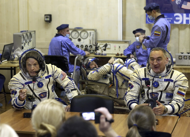 This March 25 file photo shows U.S. astronaut Steven Swanson (left) and Russian cosmonaut Alexander Skvortsov during pre-launch preparations in Kazakhstan. (AFP-Yonhap)
