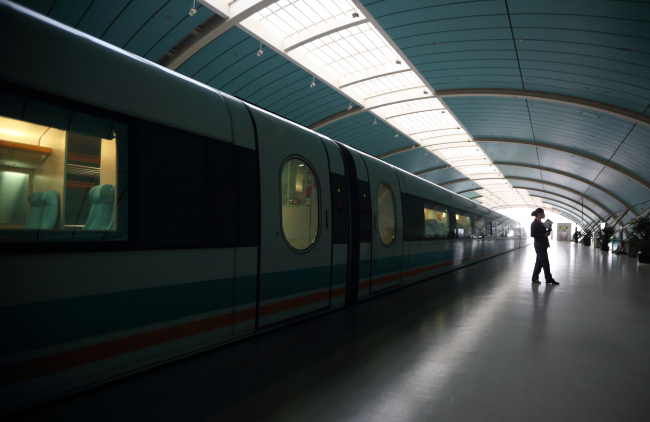 A station worker stands near a magnetic levitation train on the platform of the Long Yang Road station in Shanghai. (Bloomberg)