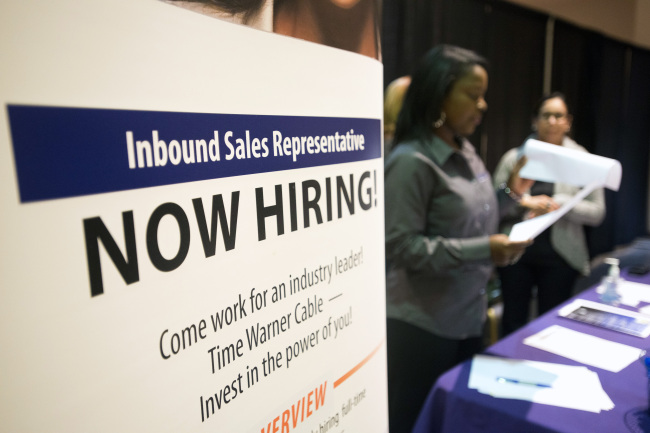 A “Now Hiring” sign stands at an exhibitors’ table at the Columbus Career Fair in Columbus, Ohio. (Bloomberg)