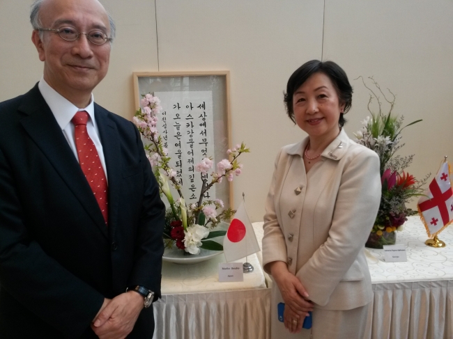 Japanese Ambassador Koro Bessho (left) and his spouse Mariko pose for a photo with Mariko’s floral arrangement and Koro’s calligraphic work during the Garden Club of Seoul’s flower show at Raemian Gallery in Anguk-dong, Seoul, Thursday. (Philip Iglauer/The Korea Herald)