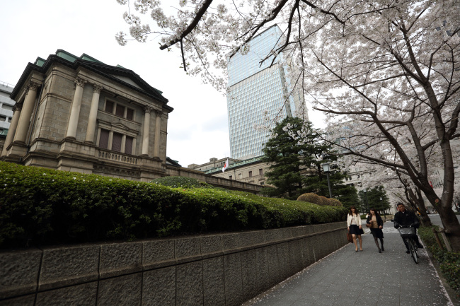 Pedestrians walk past the Bank of Japan headquarters in Tokyo. (Bloomberg)