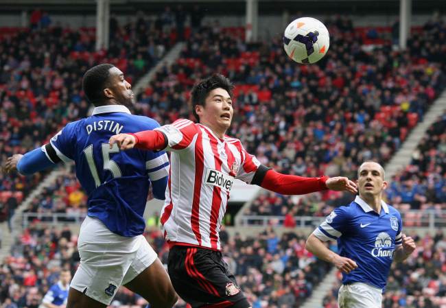 Sunderland’s Ki Sung-yueng (center) and Everton’s Sylvain Distin vie for the ball on Saturday. ( AFP-Yonhap)