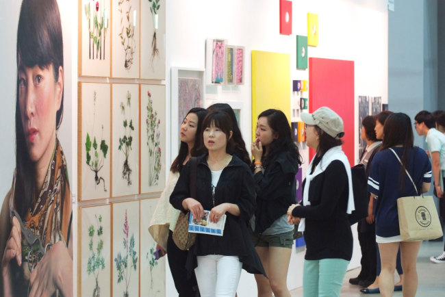 Visitors look at artworks at ArtShow Busan last year. (ArtShow Busan)