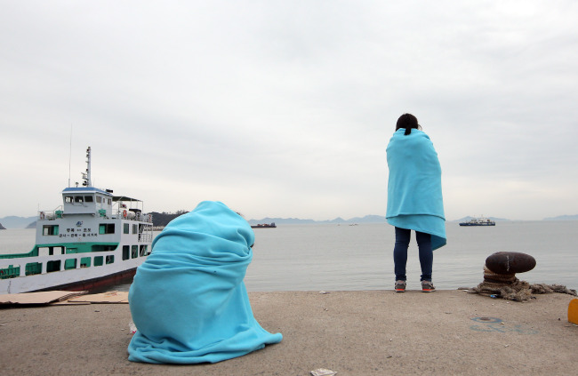 Relatives wait for their missing loved ones at a port in Jindo on Wednesday. (Yonhap)