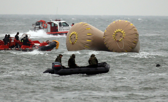 A search and rescue team looks for survivors of the sunken Sewol in the waters off coast of Jindo Island, Jeolla Province, Saturday. (Yonhap)