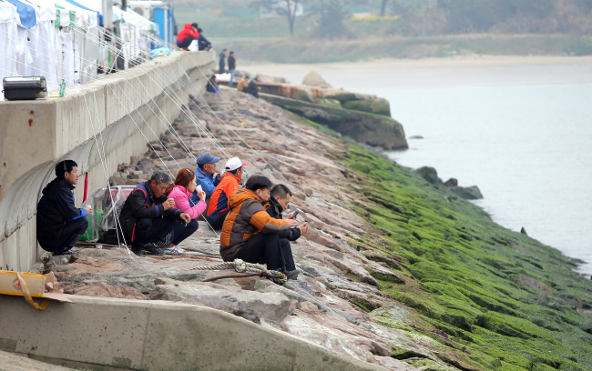 Family members of the missing passengers of the sunken Sewol wait for their return at Paengmok harbor on Jindo Island, Jeolla Province, Saturday. (Yonhap)