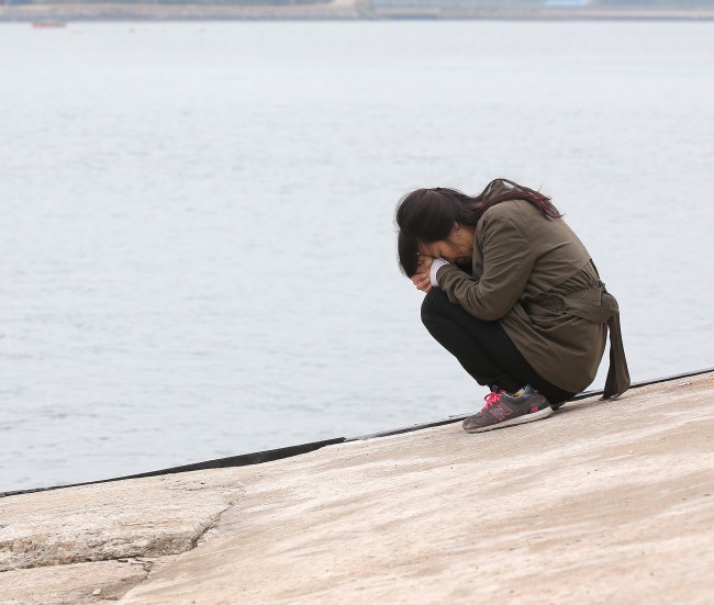 A family member of a missing passenger of the sunken ferry Sewol prays at Paengmok Port on Jindo Island, South Jeolla Province, Sunday. (Yonhap)