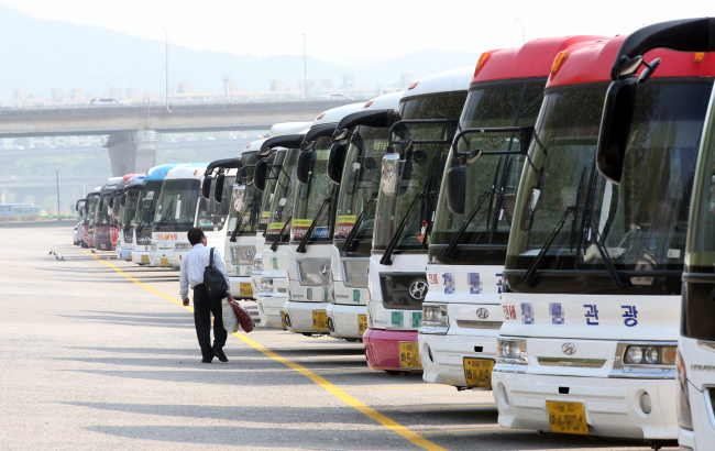 Tourist buses sit idle in a parking lot in southern Seoul on Wednesday. (Yonhap)