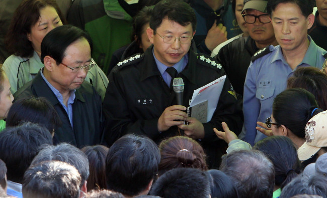 Maritime Minister Lee Joo-young (left) meets relatives of victims of the ferry disaster in Jondo Island on Thursday night. (Yonhap)