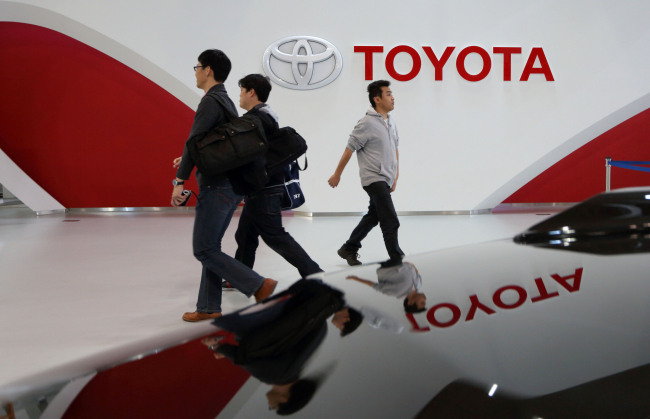 Visitors walk past the Toyota Motor Corp. logo displayed at the company’s showroom in Tokyo. (Bloomberg)