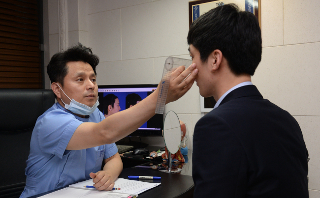 Dr. Shin Yong-ho of BK Plastic Surgery consults a patient at the clinic in Gangnam, southern Seoul.(Ahn Hoon/The Korea Herald)