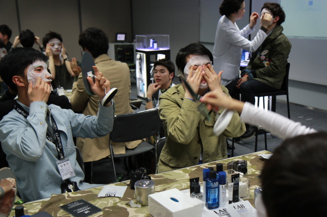 Participants try an instant moisture mask during a grooming class hosted by Lab Series. (Lab Series)