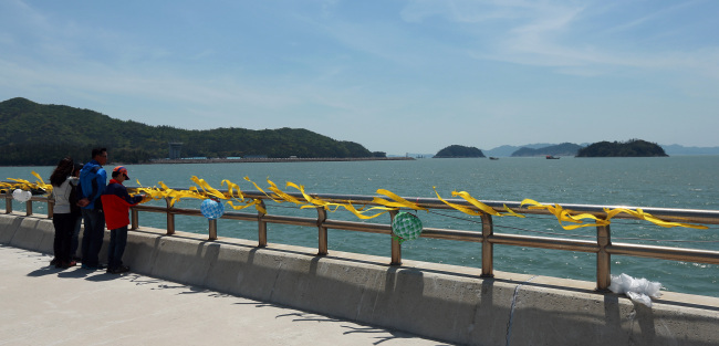 A family prays for the victims of the sunken ferry Sewol at Paengmok Port on Jindo Island on Sunday. (Yonhap)