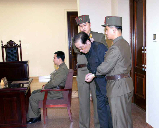 Jang Song-thaek, his hands tied with a rope, is led into court by uniformed personnel. (Yonhap)