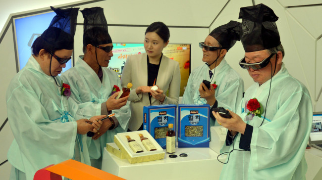 Senior citizens from Sungkyunkwan Judo Association experience next-generation IT technologies at SK T’UM, or SK Telecom Ubiquitous Museum, during an event hosted by the mobile carrier ahead of Parents’ Day, in Seoul on Wednesday. (Kim Myung-sub/The Korea Herald)