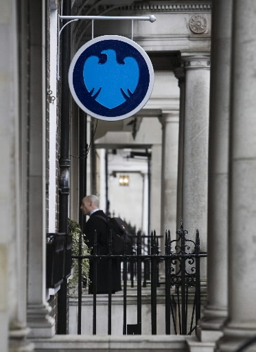 A pedestrian walks under a sign outside a Barclays bank branch in London. (Bloomberg)