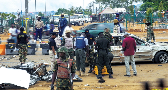 Nigerian officials inspect the scene of a car bomb attack in Nyana, Abuja, Nigeria. (EPA-Yonhap)