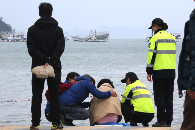 세월호 침몰 사고 발생 26일째인 11일 오전 전남 진도군 임회면 팽목항에서 오열하는 실종자 가족을 여경과 지나던 시민이 위로하고 있다. (연합)