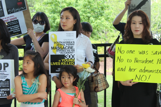 Korean-Americans hold a rally to protest against the South Korean government for its mishandling of the rescue operation of the sunken ferry Sewol in front of CNN headquarters in Atlanta on Sunday. (Yonhap)