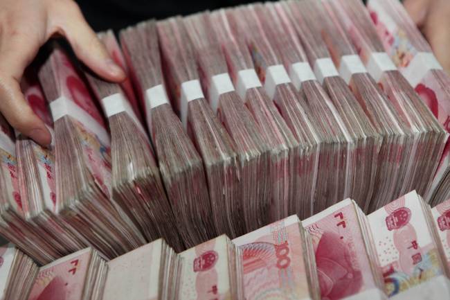 A teller counts notes in a bank in Ganyu county in east China’s Jiangsu province. (AFP-Yonhap)