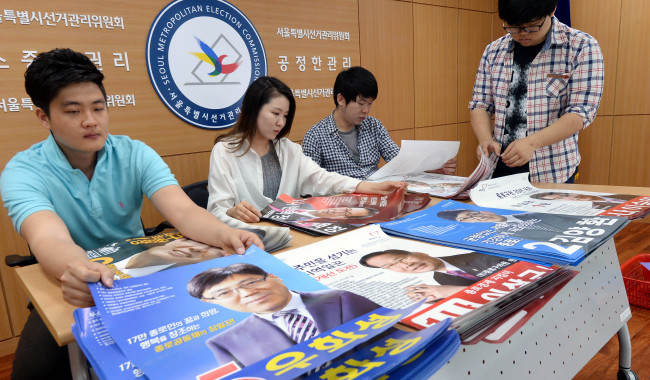 Officials prepare the campaign posters for the June 4 local elections at the National Election Commission in Seoul on Wednesday. (Ahn Hoon/The Korea Herald)