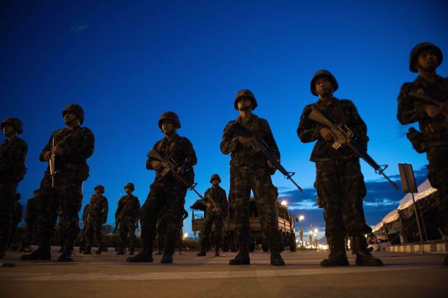 Thai army soldiers stand guard at the main entrance of the pro-government ''Red Shirts'' rally site after they shut it down and cleared protesters from the site, after Thailand's army chief announced that the armed forces were seizing power, on the outskirts of Bangkok on May 22. (Yonhap)