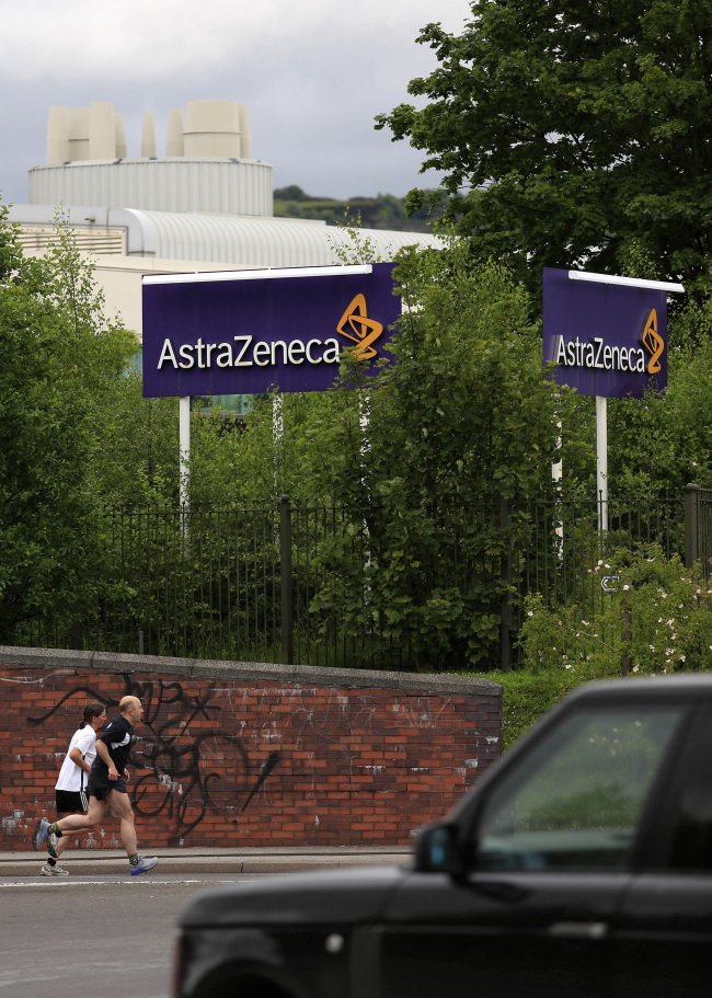 Joggers run past a sign outside AstraZeneca Plc’s factory in Macclesfield, England. (Bloomberg)