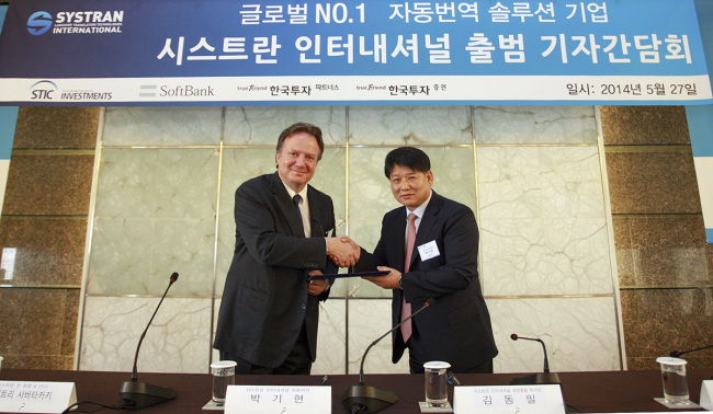 Dimitris Sabatakakis (left), former SYSTRAN chairman, and Park Ki-hyun, CEO of SYSTRAN International, shake hands ahead of a press conference to announce CSLi’s acquisition of SYSTRAN in Seoul on Tuesday. (SYSTRAN International)