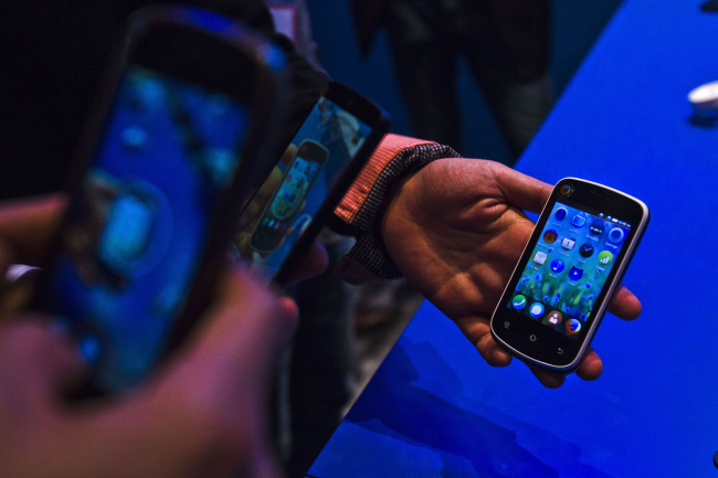 Attendees photograph an Alcatel Spreadtrum smartphone, which runs on the Firefox operating system, at the Mobile World Congress in Barcelona in February. (Bloomberg)