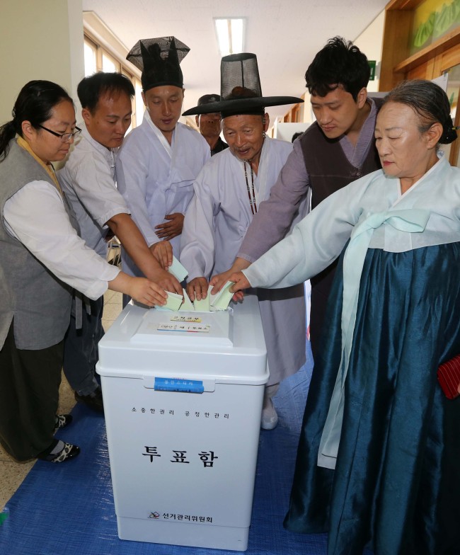 Voters wearing hanbok, traditional garment, pose at the voting room in South Chungcheong Province, Wednesday.