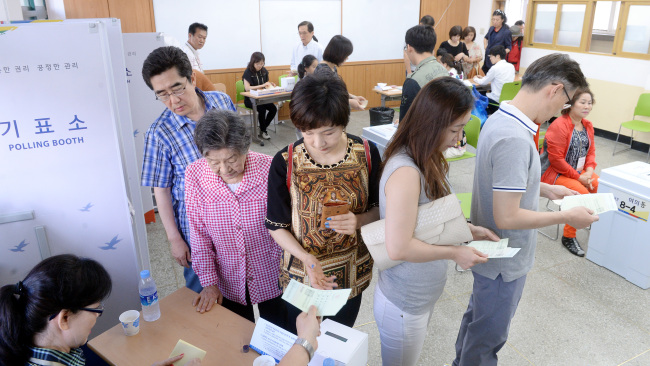 Voters stand in line at a polling station line in Yeouido, southeastern Seoul, Wednesday. (Ahn Hoon/The Korea Herald)
