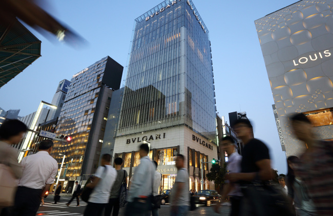 Pedestrians walk past a Tiffany & Co. store (left), Bulgari SpA store, a luxury unit of LVMH Moet Hennessy Louis Vuitton SA (center) and a Louis Vuitton store in the Ginza district of Tokyo. (Bloomberg)