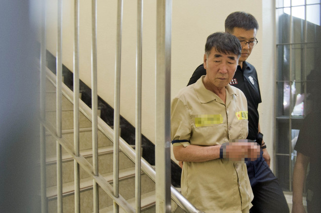 Lee Joon-seok, captain of the ill-fated ferry Sewol, is guided to a courtroom of the Gwangju District Court for a trial on Tuesday. (Yonhap)