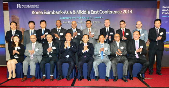 Export-Import Bank of Korea CEO Lee Duk-hoon (front row, fourth from left) poses with participants of the Korea Eximbank Asia & Middle East Conference 2014 including Vice Finance Minister Choo Kyung-ho (front row, fifth from left) and Vietnamese Vice Minister of Transport Truong Tan Vien (front row, third from right) on Wednesday. (Korea Eximbank)