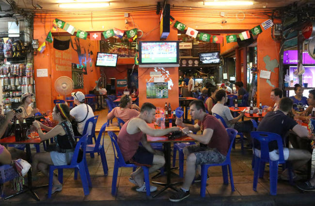 Tourists and locals eat and drink at a restaurant in Bangkok’s Khaosan road, Thailand, Saturday. The generals who seized power in Thailand have lifted a nationwide curfew, giving a green light for the capital’s red-light districts, nightclubs and pubs to roar back to life. (AP-Yonhap News)