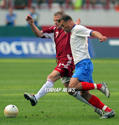 Vasily Berezutski (Right) of Russia fights for the ball with Maris Smirnovs (Left) of Latvia during their friendly soccer match in Moscow, 16 August 2006. (Yonhap)