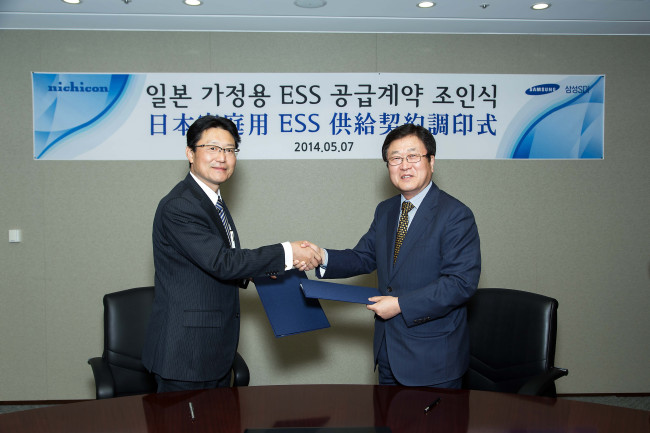 Samsung SDI chief executive Park Sang-jin (right) shakes hands with Nichicon’s president Shigeo Yoshida after signing an energy storage system supply deal in May in Seoul. (Samsung SDI)