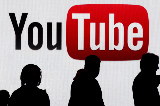 Attendees walk past the YouTube logo at the International Consumer Electronics Show in Las Vegas. (Bloomberg)